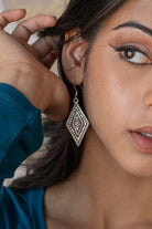 Close-up of a woman adjusting her hair over her ear wearing Hill Tribe Silver Diamond earring
