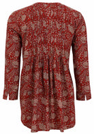 Red based floral print cotton button through shirt with long sleeves, and pin tucks across the bodice, front and back