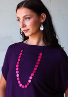 woman wearing pink wooden bead necklace
