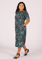 Model wears a shin length cotton dress with a sweet floral print