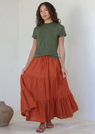 Model wearing a 100% cotton skirt in rust shade paired with a green top