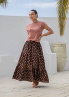 Model wearing 100% cotton maxi skirt with elasticised waist and drawstring in dark brown based floral print.