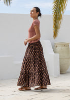 Model pairs crinkled, floral cotton maxi skirt with wide neck rayon top in dusty rose.