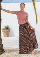 Model wears brown floral cotton maxi skirt with elastic waist and drawstring.