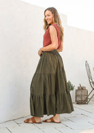 Model wearing a plain olive green cotton skirt with elasticated and drawstring waistband.