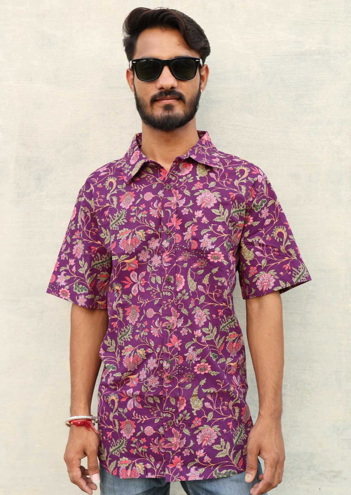 Man poses in cotton relaxed fit short sleeve shirt in purple based floral print