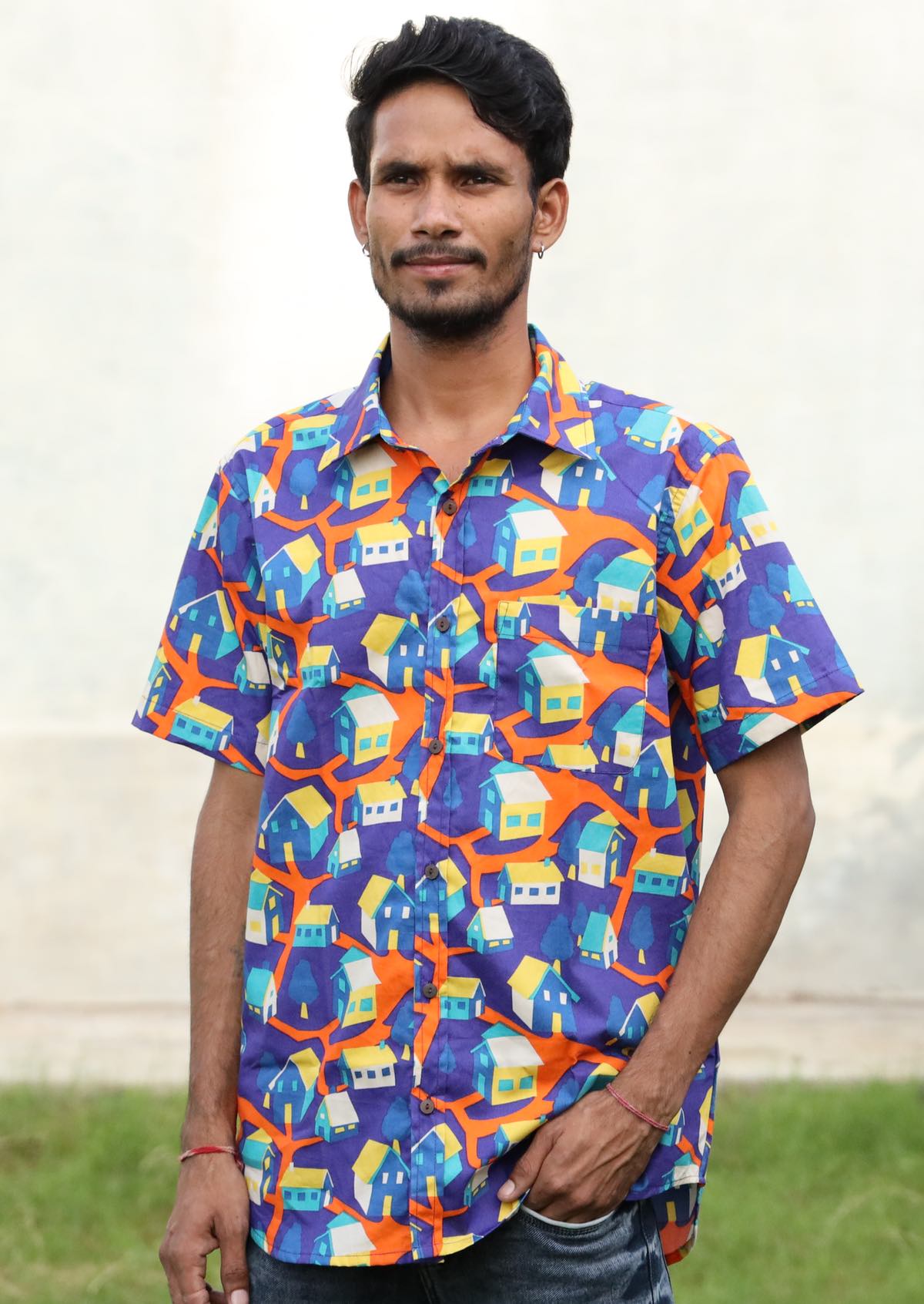 Man poses short sleeve button through collared cotton shirt in fun bright print