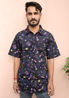 Man wears relaxed fit cotton shirt with fun colourful astro print on a black base