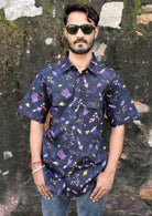 Man poses in cotton relaxed fit short sleeve shirt with one pocket and coconut buttons