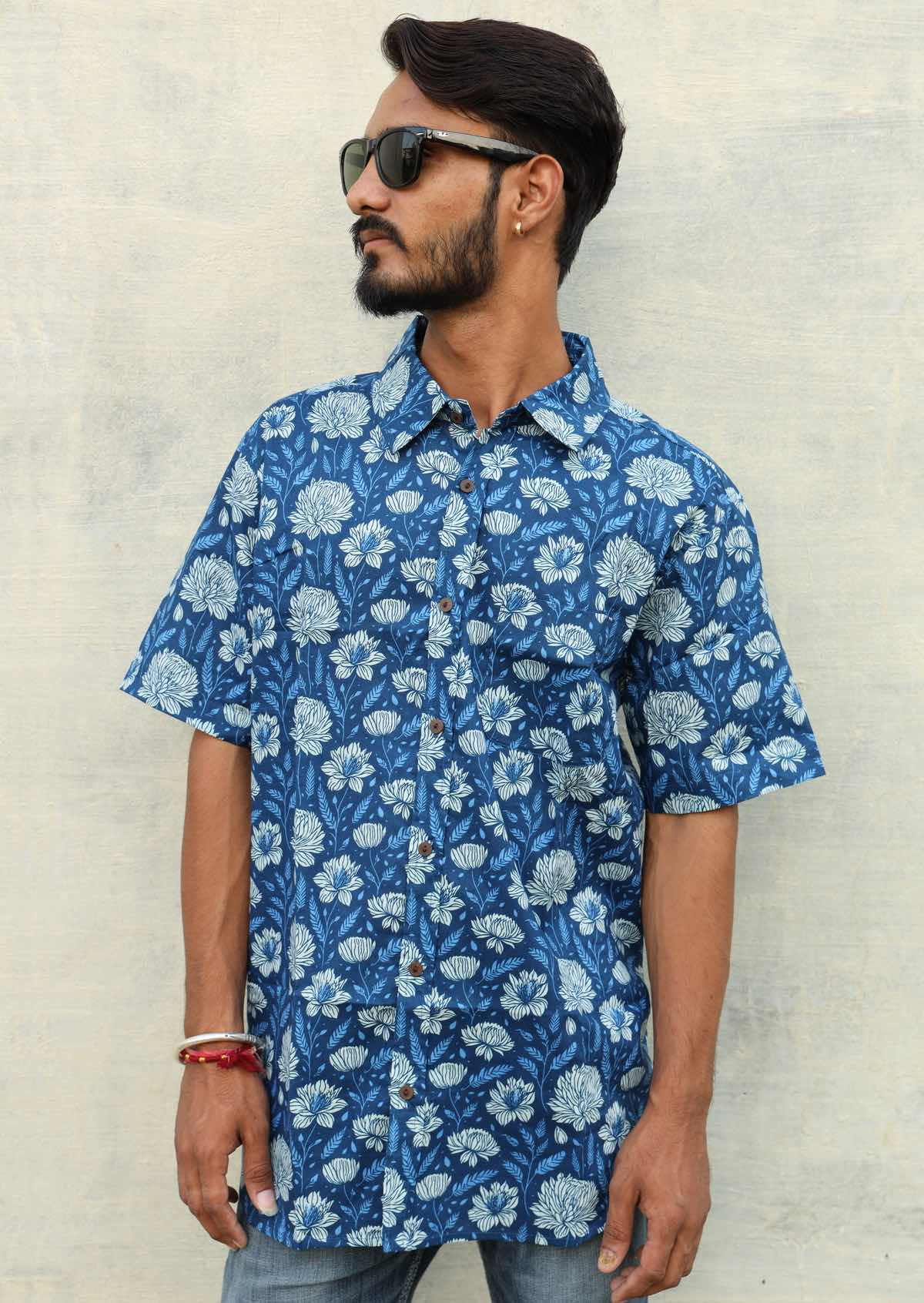 Man wearing relaxed fit cotton short sleeve shirt with coconut button, in blue floral print