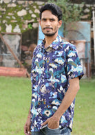 Man poses in blue floral print short sleeved shirt with collar and one breast pocket