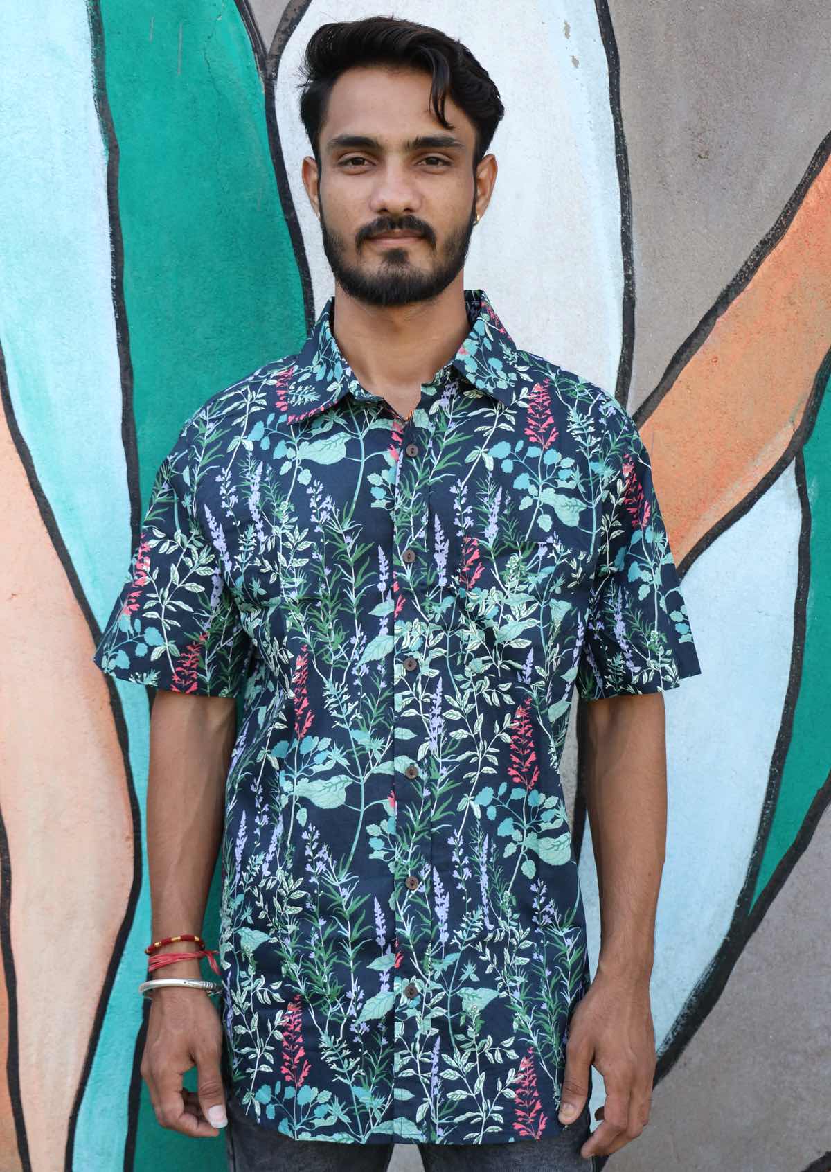 Man wears button through cotton shirt in floral print with pops of pink and lilac