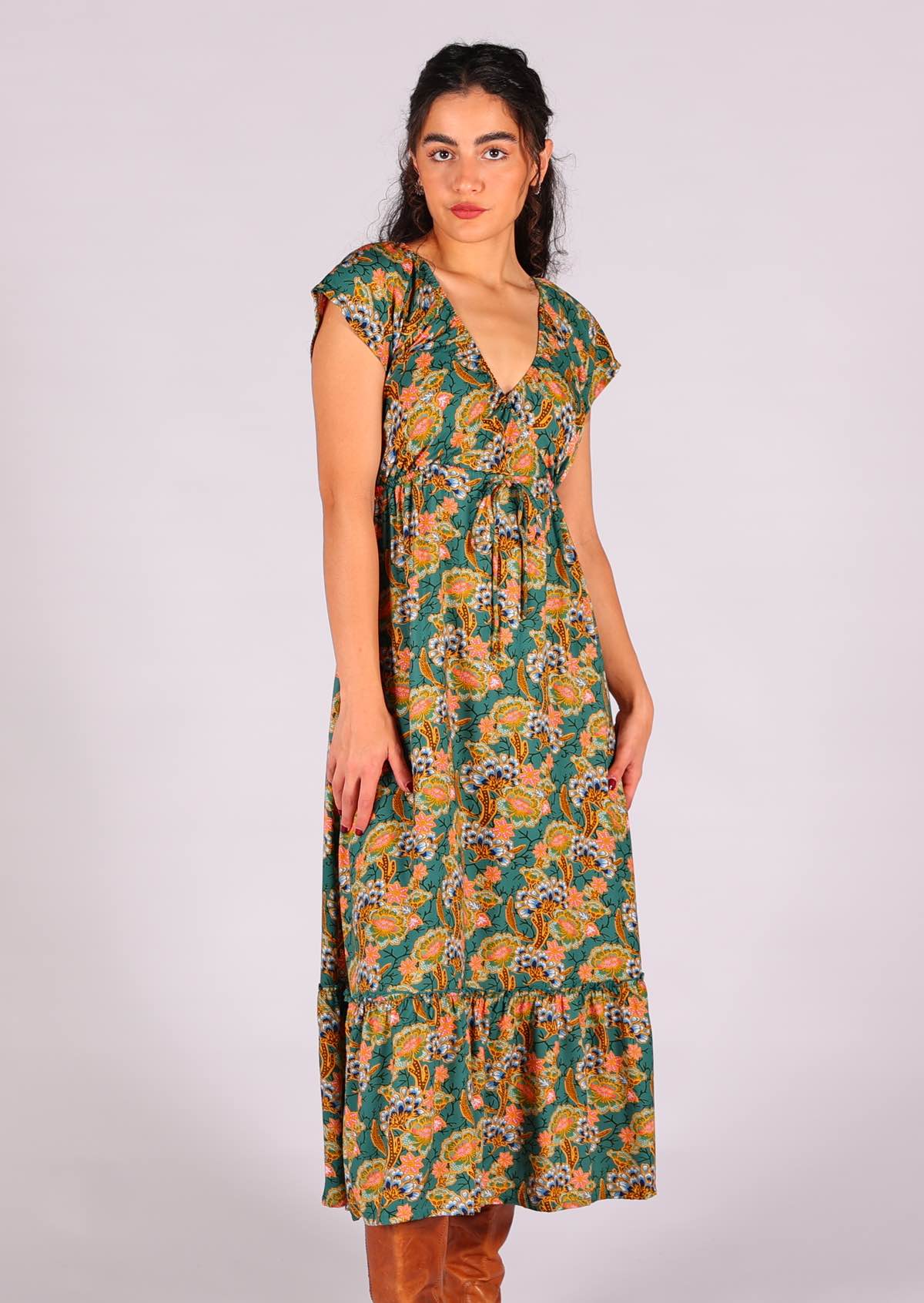 Model wearing 100 percent v-neck rayon maxi dress with deep ruffle tier at base