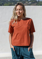 Woman wearing a plain top in rust shade, 100% cotton top with round neckline