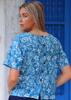 100% cotton blue floral blouse on woman with blonde hair button down back