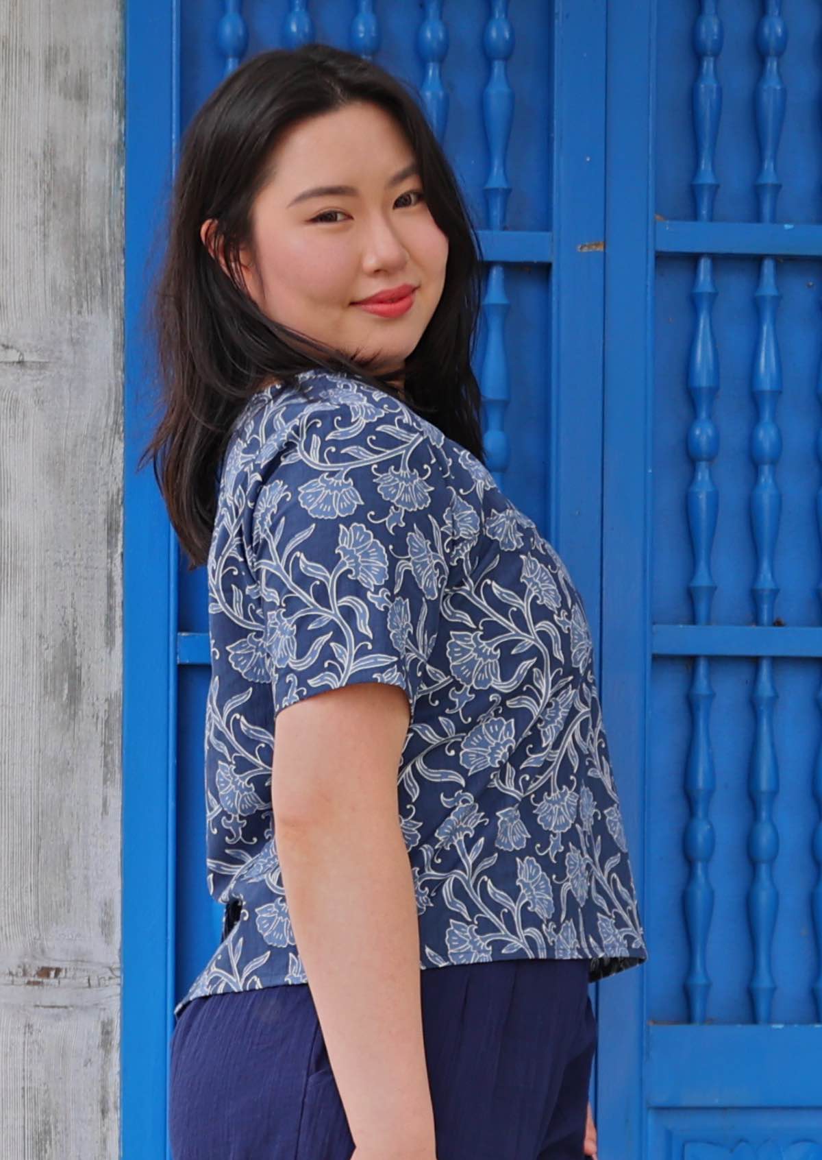 Model posing wearing floral navy blue boxy blouse 100 percent cotton