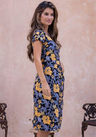Woman posing in a retro floral sundress with round neckline, cap sleeves, A line skirt and pockets