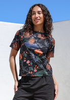 Model wears 100% cotton black based botanical print top with pink and orange florals