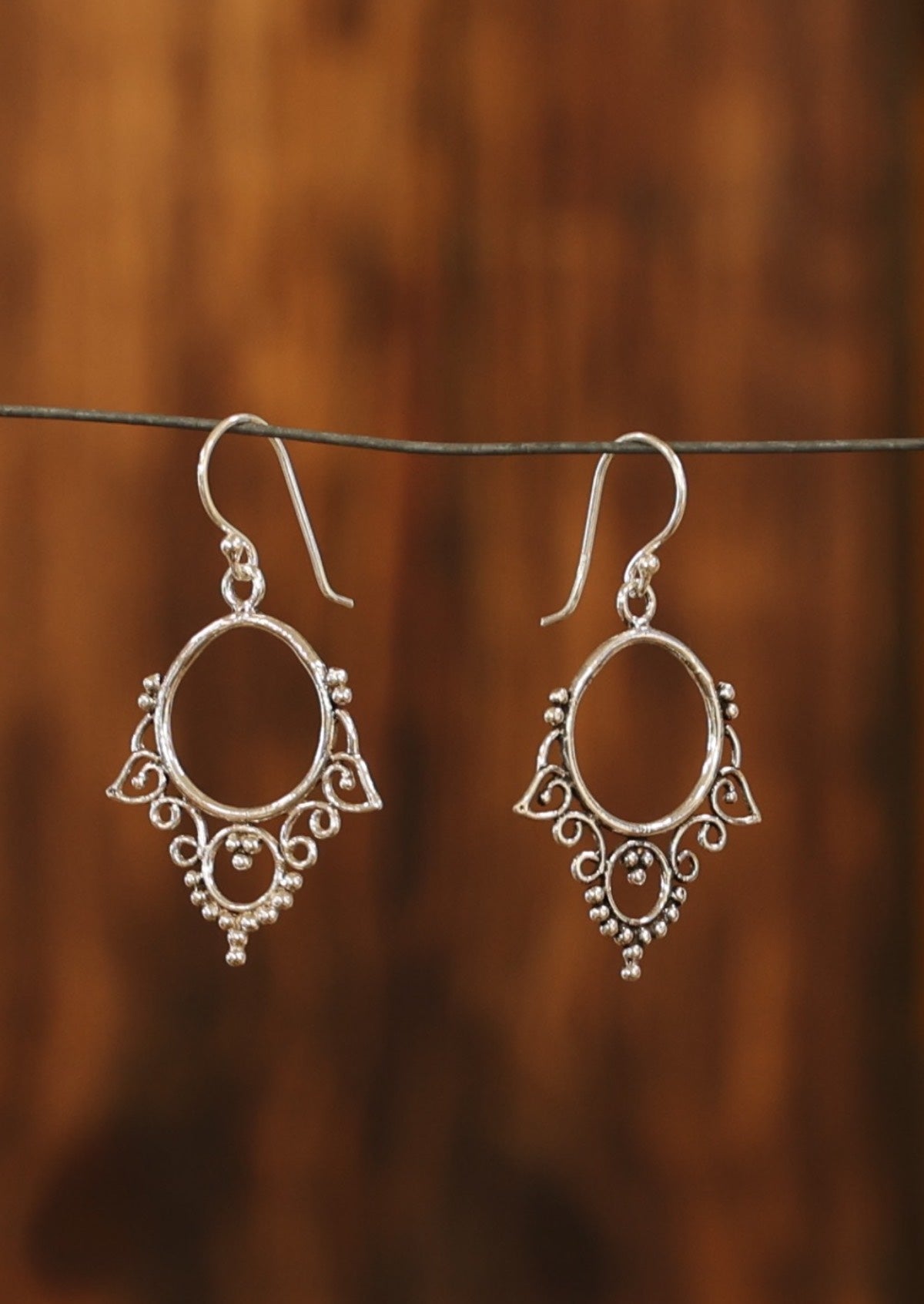 Sterling silver hook earrings crafted from wire details around a small hoop