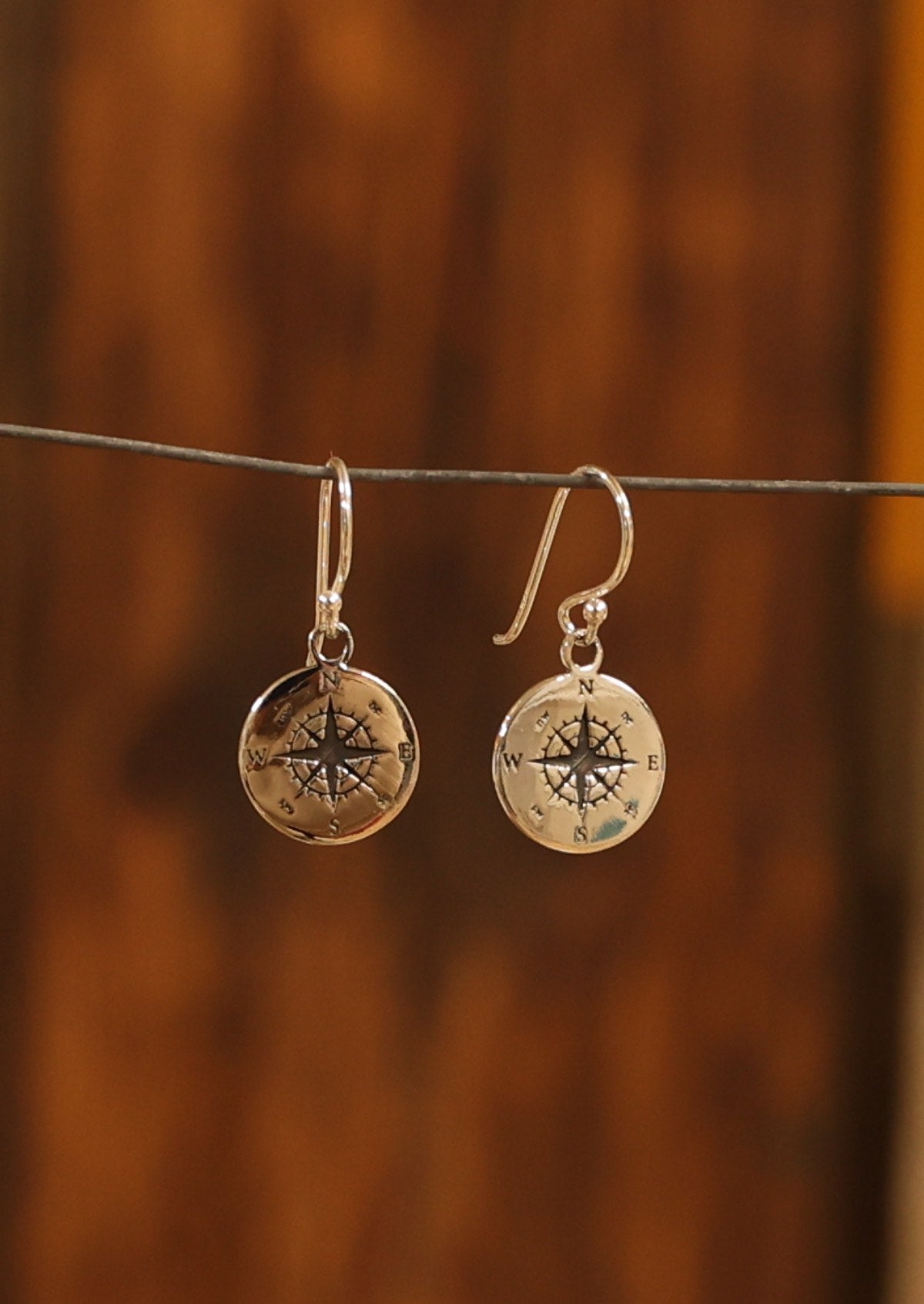 Silver hook earrings with compass disc
