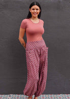 Model standing with hands behind back wearing 100 percent cotton harem pants with pockets