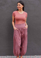 Model standing wearing 100 percent cotton harem pants with hands in pockets