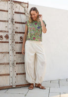 Models poses in white cotton wide leg pants with elasticated ankle