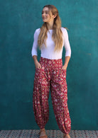 Model wears 100% cotton loose pants in red cranberry base featuring elasticated waist and ankles.Paired with boat neck top white.