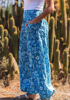 Close up of woman's blue floral print cotton harem pants with a wide waistband with hands in pockets