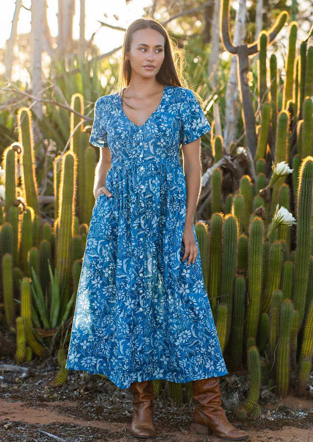 woman in blue cotton floral v neck maxi dress with hands in pocket