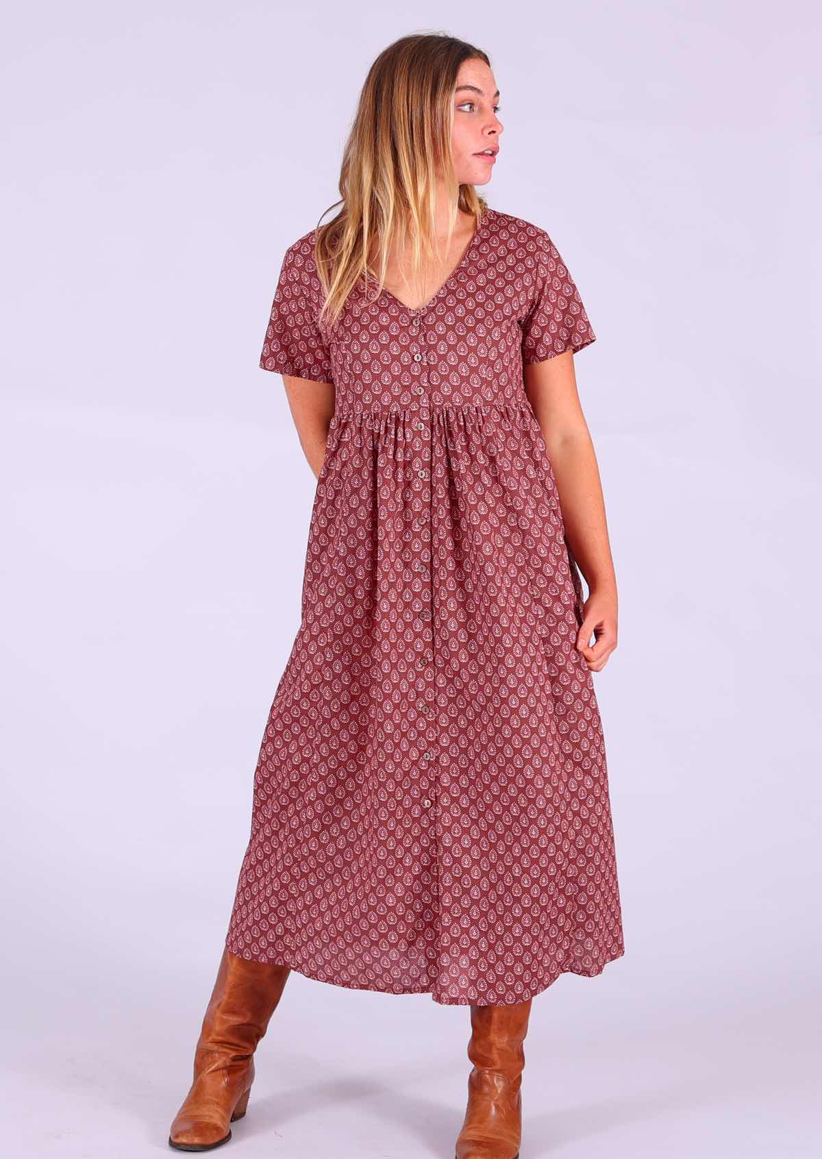 Model standing with hand behind back wearing 100 percent cotton dark terracotta maxi sundress