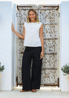 Woman wears cotton sleeveless top in plain white colour with gathers under the square neckline yoke
