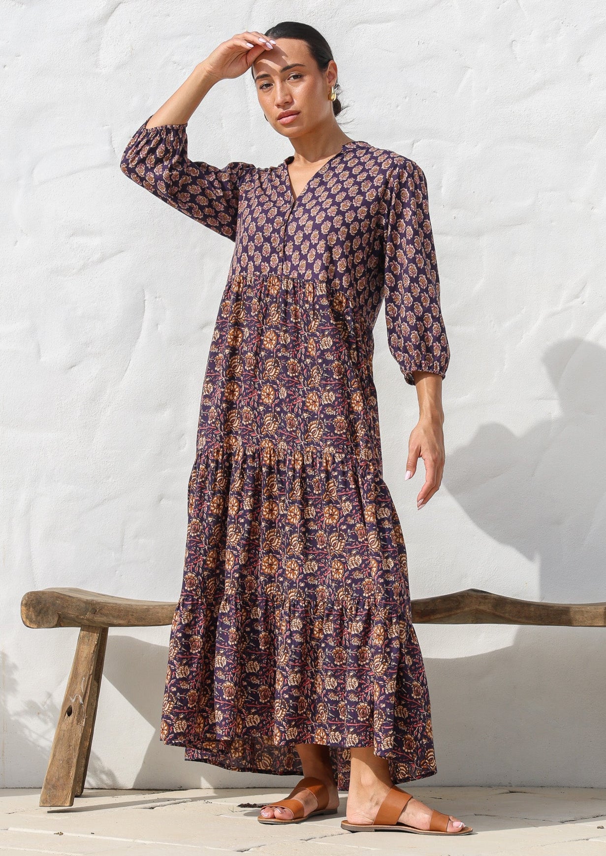 Model wears dark purple based floral cotton dress with pockets, 3/4 sleeves, V neck and mandarin collar.