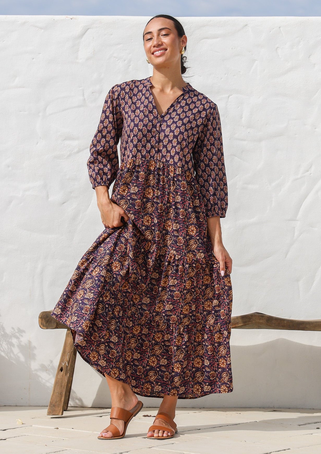 Model wearing a 3 tiered cotton maxi dress in combination of two beautiful purple based floral prints - Raani and kumari. 
