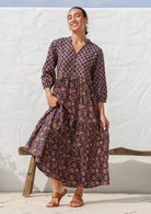 Model wearing a 3 tiered cotton maxi dress in combination of two beautiful purple based floral prints - Raani and kumari. 