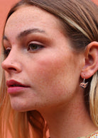 woman wearing small silver bird earrings