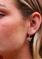 woman wearing small silver robin bird earrings