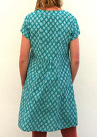 Model wearing 100 percent cotton aqua short sleeve beach dress back view showing pleated feature 