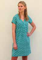 Model standing with hand on hip wearing 100 percent cotton aqua v-neck short sleeve beach dress