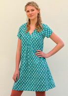 Model standing with hand on hip wearing 100 percent cotton aqua short sleeve beach dress