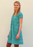 Model standing to the side wearing 100 percent cotton aqua short sleeve beach dress