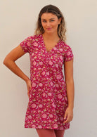 Woman wears red based floral cotton cap sleeve short tunic with top stitched V-neckline