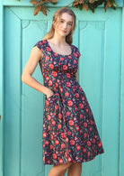 Model Wearing dark blue based cotton retro style dress with cap sleeves, piped details and pockets.