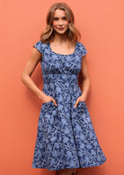 Women standing with hands in pockets wearing Scarlett Dress Neela 100 percent cotton retro dress in a navy floral print