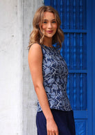 Woman standing side view wearing Shell Top Neela 100 percent navy blue cotton ninteen sixties style sleeveless blouse