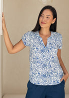 woman wearing a relaxed fit, white based blue floral print cotton top. 