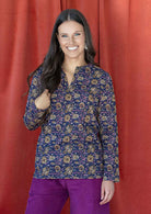 Model wearing long sleeved 100% cotton top with round neckline and V cutout.