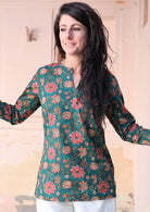 Woman wears a relaxed fit cotton long sleeve top in a green based floral print