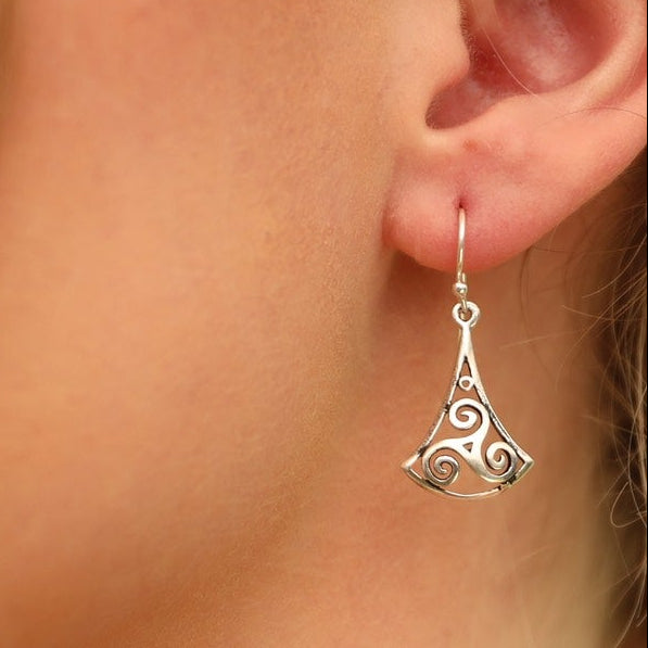Model wears sterling silver swirly triangle hook earrings