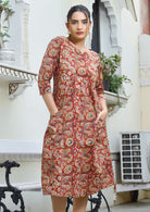 Model wears 100% cotton indian floral print dress with 3/4 sleeves and hands in pocket.